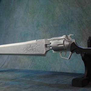 May include: A silver-colored fantasy weapon, a hybrid of a revolver and a sword, is displayed on a black stand. The blade has an ornate design. The handle is black with a silver charm attached. The background is a mottled blue and green.