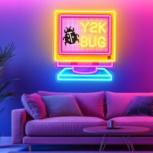 May include: A neon sign shaped like a retro computer monitor, displaying the text "Y2K BUG" and a pixelated bug graphic. The sign is yellow, pink, and blue, mounted on a purple wall above a pink sofa. The room has a modern, retro aesthetic.