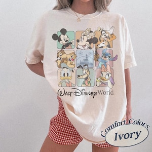 May include: Ivory-colored t-shirt featuring a grid of Disney characters including Mickey Mouse, Minnie Mouse, Goofy, Chip and Dale, Stitch, Donald Duck, Pluto, and Daisy Duck. The words "Walt Disney World" are printed below the grid.