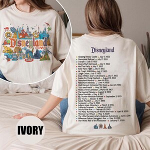 Puede incluir: Camiseta de color marfil con un gr&aacute;fico colorido de Disneyland en la parte delantera. La parte trasera de la camiseta enumera las atracciones de Disneyland y sus fechas de apertura. Estilo c&oacute;modo e informal.