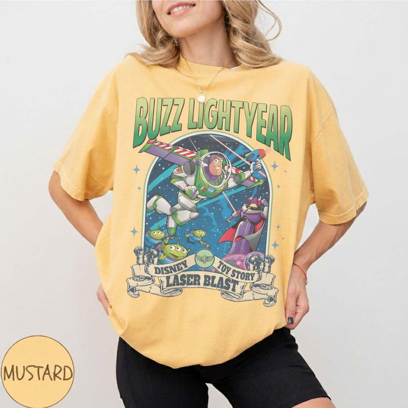 Peut inclure: T-shirt moutarde avec un graphisme de Buzz l'&Eacute;clair de Toy Story. Le motif comprend le texte "Buzz Lightyear" en vert et "Disney Toy Story Laser Blast" sur une banni&egrave;re. Le t-shirt a des manches courtes.