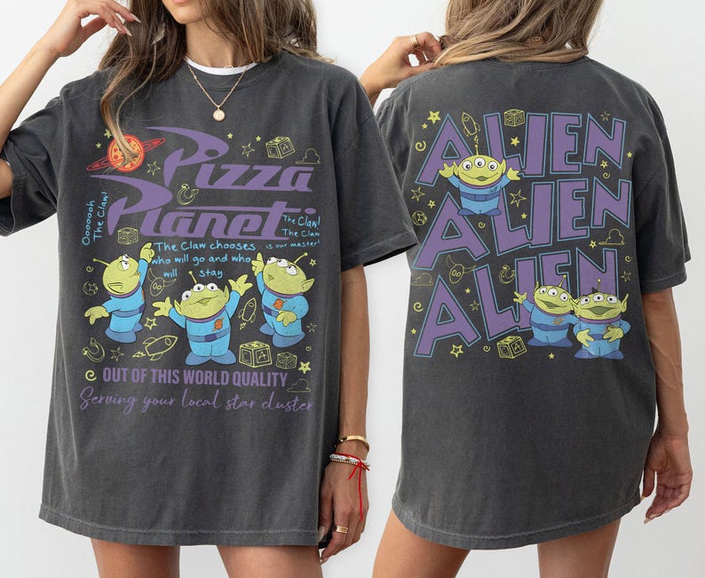 May include: Dark gray t-shirt featuring the Pizza Planet logo and alien characters. The front of the shirt has the text "Pizza Planet" and "Out of this world quality". The back of the shirt has the word "Alien" repeated three times.