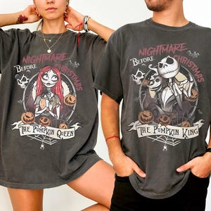 May include: Two dark gray t-shirts featuring characters from "The Nightmare Before Christmas." One shirt displays Sally, pumpkins, and the text "The Pumpkin Queen." The other shows Jack Skellington, pumpkins, and "The Pumpkin King."