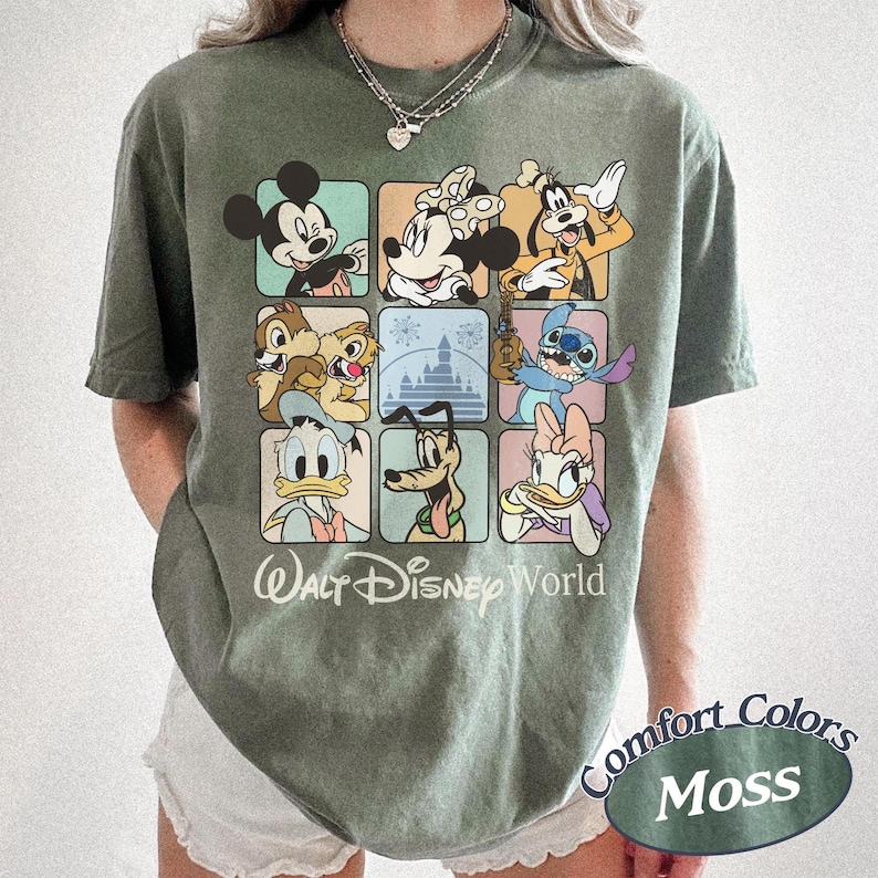 May include: Moss green t-shirt featuring a grid of Disney characters including Mickey Mouse, Minnie Mouse, Goofy, Chip and Dale, Stitch, Donald Duck, Pluto, and Daisy Duck. The words "Walt Disney World" are printed below the grid.