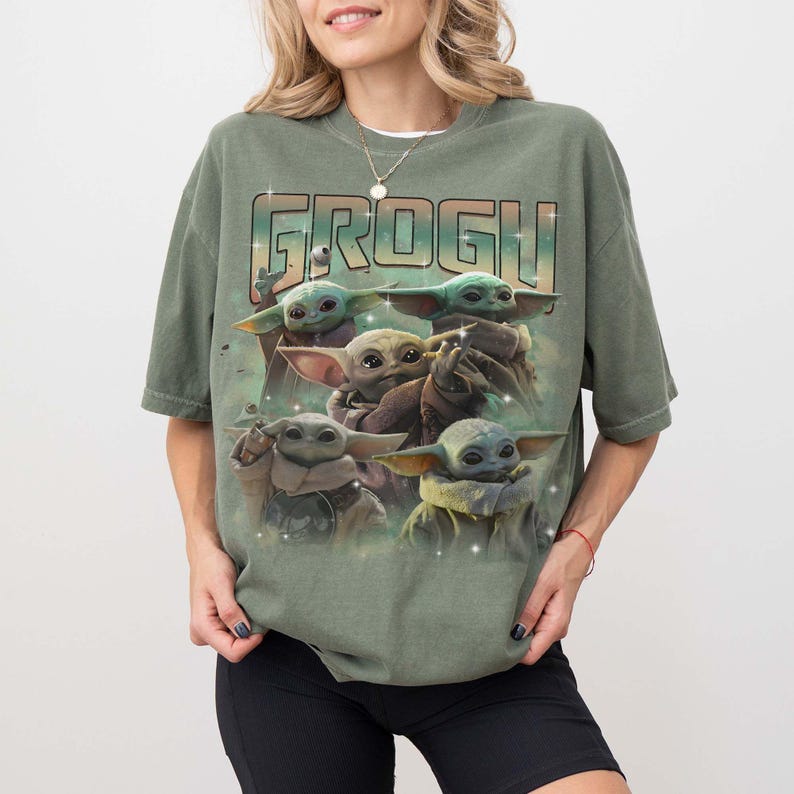 Puede incluir: Camiseta verde con un dise&ntilde;o de Grogu, tambi&eacute;n conocido como Baby Yoda, de The Mandalorian. El dise&ntilde;o incluye m&uacute;ltiples personajes de Grogu en varias poses. La palabra "GROGU" est&aacute; impresa en la parte superior en una fuente estilizada.