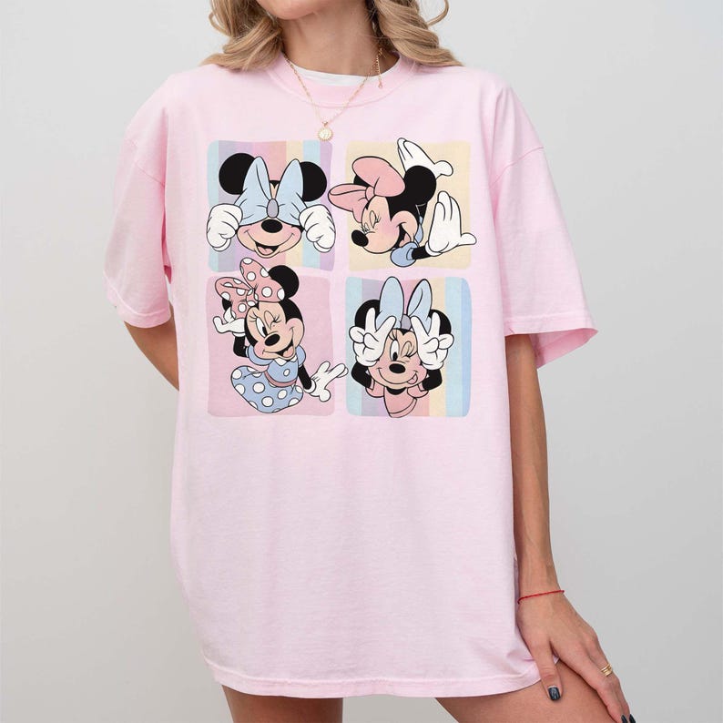 Może przedstawiać: Jasnor&oacute;żowa koszulka z czteropanelową grafiką przedstawiającą Minnie Mouse w r&oacute;żnych pozach. Każdy panel ma pastelowe tło. Myszka Minnie jest przedstawiona ze swoją charakterystyczną kokardą i sukienką w kropki. Koszulka ma luźny, obszerny kr&oacute;j.