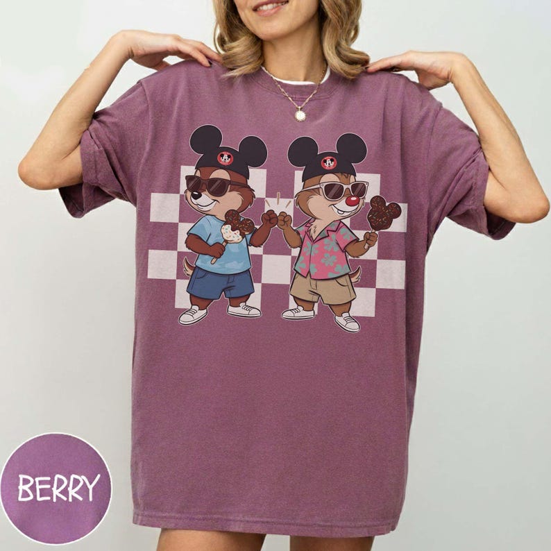 May include: Berry-colored t-shirt featuring a cartoon illustration of two chipmunks wearing sunglasses and Mickey Mouse hats, holding ice cream treats. The design is set against a checkered background. The word "BERRY" is printed on a circular label.