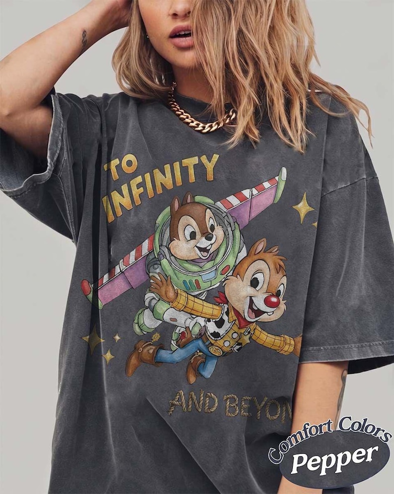 Puede incluir: Camiseta gris oscuro con Chip y Chop como Buzz Lightyear y Woody, con el texto "TO INFINITY AND BEYOND". La camiseta tiene un aspecto desgastado y el logo Comfort Colors Pepper.