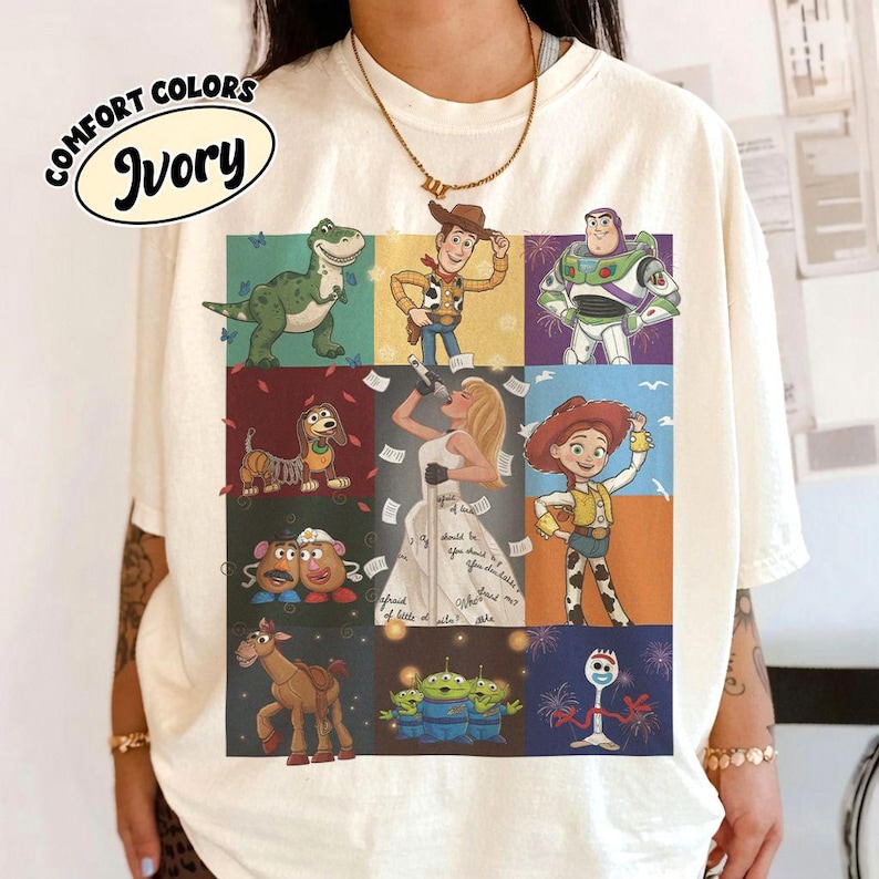 May include: An ivory short-sleeve t-shirt featuring a grid of nine colorful illustrations of characters from the Toy Story film franchise, including Woody, Buzz Lightyear, Jessie, Rex, Slinky Dog, Mr. and Mrs. Potato Head, Bullseye, and Forky.