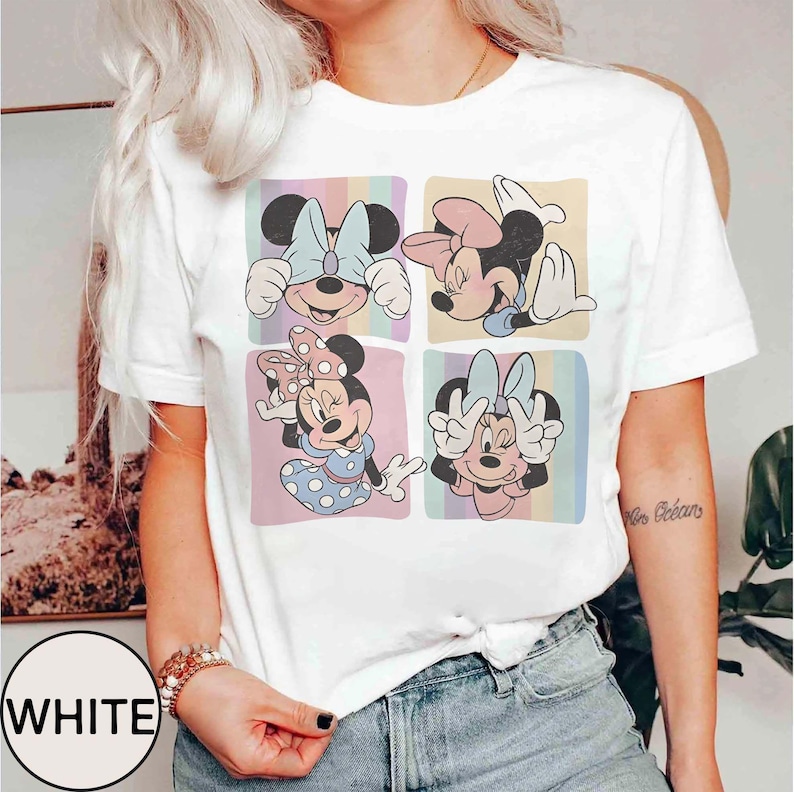 Może przedstawiać: Biała koszulka z kolorową grafiką Myszki Minnie w czterech r&oacute;żnych pozach, każda w pastelowym kwadracie. Słowo "WHITE" jest wydrukowane w białym okręgu po lewej stronie u dołu.