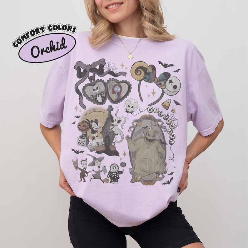 May include: An orchid-colored short-sleeve t-shirt featuring a graphic print of characters and motifs from The Nightmare Before Christmas, including Jack Skellington, Sally, Oogie Boogie, and Zero, with the text COMFORT COLORS Orchid.