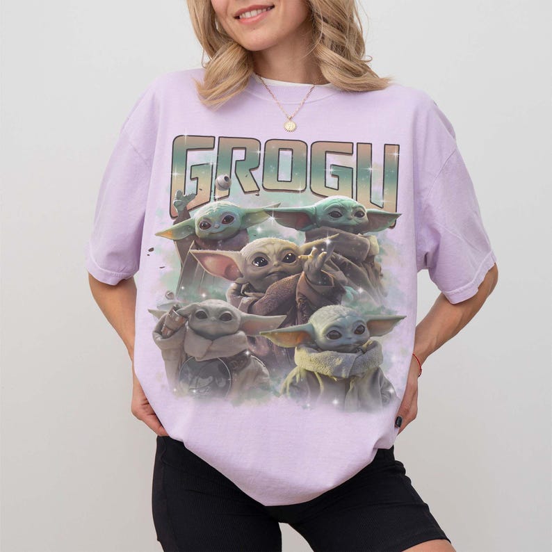 Puede incluir: Camiseta de color lila claro con un gr&aacute;fico de Grogu, tambi&eacute;n conocido como Baby Yoda, de The Mandalorian. La palabra "GROGU" est&aacute; impresa en la parte superior en una fuente estilizada. El gr&aacute;fico muestra m&uacute;ltiples im&aacute;genes de Grogu.