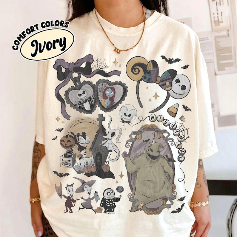 May include: An ivory t-shirt featuring a graphic print of characters and motifs from The Nightmare Before Christmas, including Jack Skellington, Sally, Oogie Boogie, Zero, and various spooky elements like spiderwebs, bats, and candy corn.