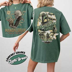 Op de afbeelding: Lichtgroen t-shirt met een afbeelding van The Mandalorian en Grogu. Het ontwerp aan de voorkant bevat de tekst "MANDALORIAN" en "THIS IS THE WAY". Het ontwerp aan de achterkant toont het Star Wars-logo en de tekst "THE MANDALORIAN AND GROGU".
