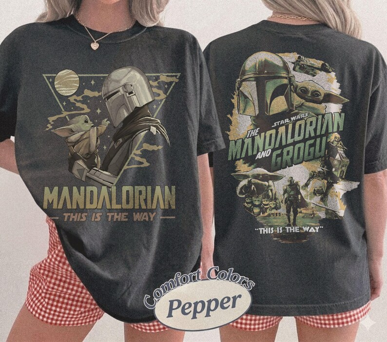Op de afbeelding: Donkergrijs T-shirt met een afbeelding van The Mandalorian en Grogu uit Star Wars. De voorkant toont "MANDALORIAN" en "THIS IS THE WAY". De achterkant toont "THE STAR WARS MANDALORIAN AND GROGU" en "THIS IS THE WAY".