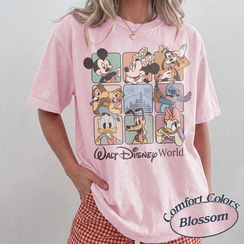 May include: A light pink t-shirt featuring a grid of Disney characters including Mickey Mouse, Minnie Mouse, and Stitch. The shirt has the words "Walt Disney World" printed below the grid and "Comfort Colors Blossom" in an oval on the bottom right.