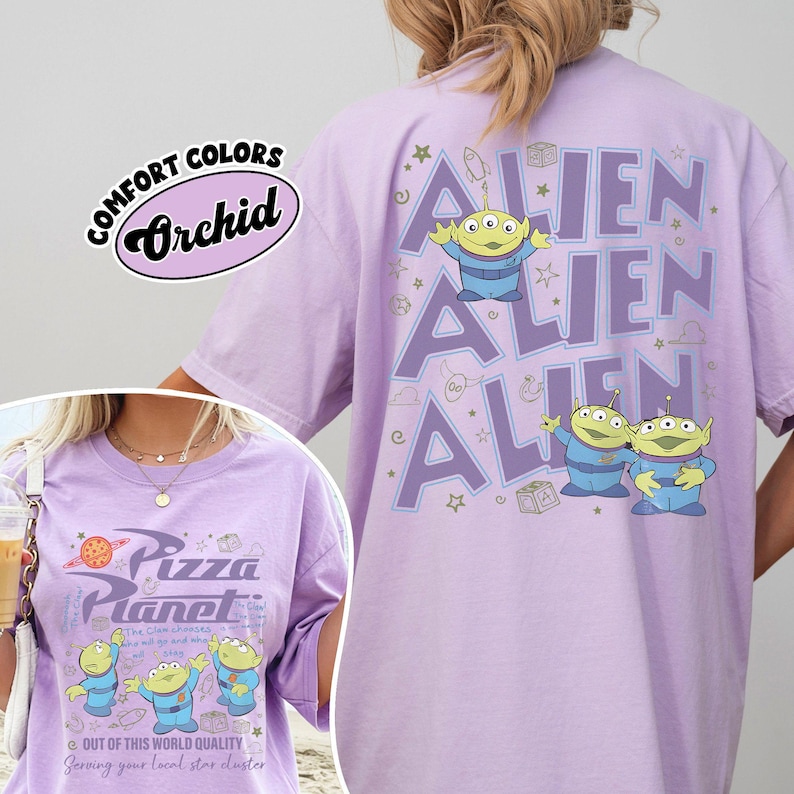 May include: A light purple t-shirt with the text "ALIEN" repeated three times, and cartoon aliens. The front of the shirt features the text "Pizza Planet" and more cartoon aliens. The shirt is labeled "Comfort Colors Orchid".