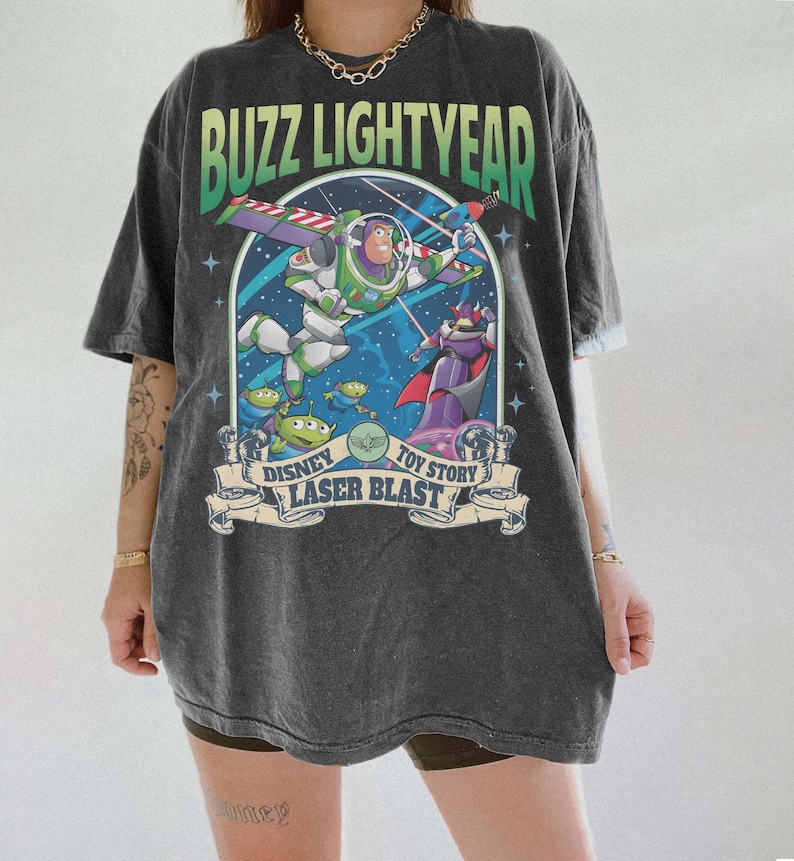 Peut inclure: T-shirt gris fonc&eacute; avec un graphisme color&eacute; de Buzz l'&Eacute;clair de Toy Story. Le motif comprend les textes "Buzz l'&Eacute;clair", "Disney", "Toy Story" et "Laser Blast". Le t-shirt a des manches courtes et une coupe d&eacute;contract&eacute;e.
