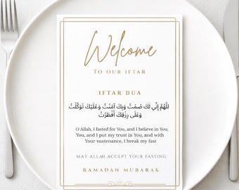 May include: A rectangular white card with gold borders and text reading Welcome To Our Iftar, Iftar Dua, the Arabic prayer, its English translation, May Allah Accept Your Fasting, and Ramadan Mubarak, centered on a white plate with a fork and knife.