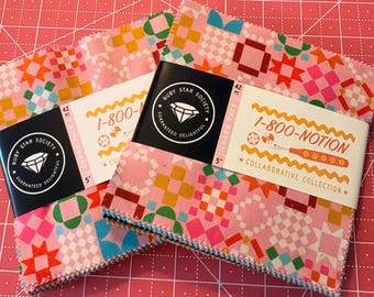 May include: Two stacks of colorful fabric squares with geometric patterns in pink, orange, green, and blue. Each stack is labeled with a black tag that reads "RUBY STAR SOCIETY" and "GUARANTEED DELIGHTFUL". One stack has a label that reads "1-800-NOTION".