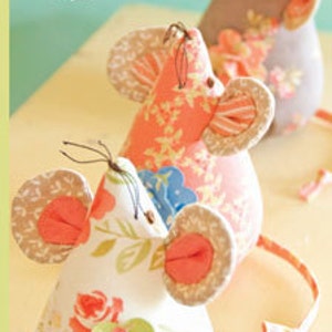 May include: Three fabric mice plush toys featuring floral patterns in white, coral, and grey. Each mouse has round ears, thin dark thread whiskers, and a long fabric tail. The packaging includes the text Fig Tree threads, Three Blind Mice, and FTQ# 941.