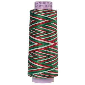 May include: A spool of Mettler silk-finish cotton mercerized thread, featuring a festive pattern of red, green, and white stripes. The thread is wound around a cylindrical core with a purple base, perfect for sewing and crafting projects.