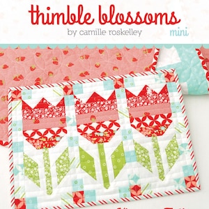 May include: A mini quilt featuring three red tulip designs with green stems and leaves, set against a white background with blue and red accents. The quilt is bordered with a red and white striped fabric. The text "Vintage Tulips #190" is visible.