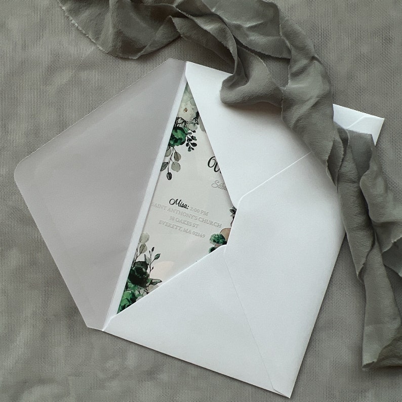 Op de afbeelding: Een witte envelop met een bloemenontwerp op de binnenklep. De tekst op de binnenklep luidt "Misa: 2:00 PM Saint Anthony's Church 38 Oakes St Everett, MA 02149".