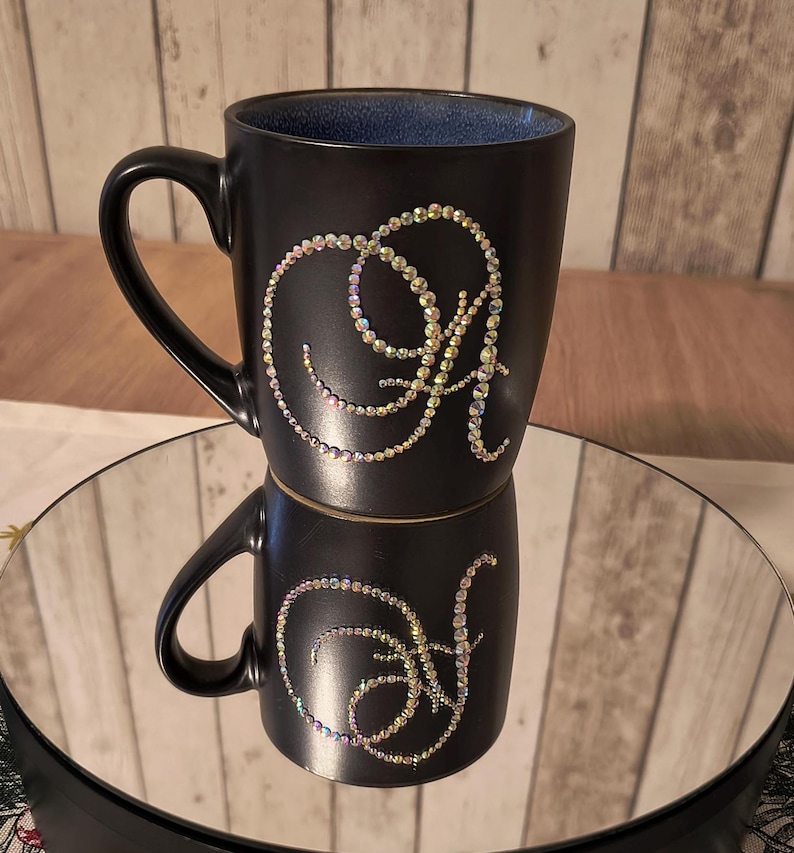 May include: Black ceramic mug with a blue interior and a single initial "A" in iridescent rhinestones.