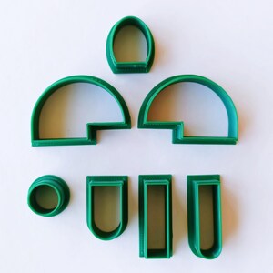 May include: A set of seven green plastic cookie cutters shaped like different windows and arches.