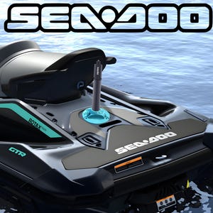 May include: A black and teal jet ski with the text "SEA DOO" in white. The jet ski has a black seat and a teal accent. A black and teal accessory is mounted on the front of the jet ski.