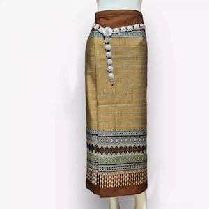 以下が含まれることがあります： 茶色と金のストライプの入ったスカートで、茶色のウエストバンドと銀色のビーズのベルトが付いています。スカートの裾には幾何学模様があります。
