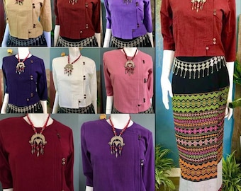 May include: A collection of nine women's tops in various colors, including red, purple, pink, white, and blue. Each top features a unique design with a button closure on the side and a decorative pendant necklace. The tops are made of a soft, comfortable fabric and are perfect for a variety of occasions.