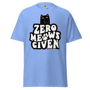 Puede incluir: Camiseta azul claro con un gato negro y el texto "Zero Meows Given" en blanco. El texto está en una fuente de estilo retro. El gato mira hacia la derecha y tiene los ojos rojos. El texto "#KALI CAT CLUB" está debajo del texto principal.