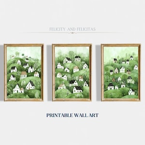Może przedstawiać: Trzy oprawione akwarele przedstawiające zielone wzg&oacute;rze z białymi domami. Obrazy są zatytułowane "Felicity and Felicitas" oraz "Printable Wall Art".