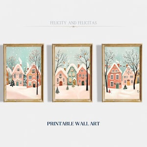 May include: Three printable wall art prints featuring a winter scene with snow-covered houses decorated with lights and ornaments. The houses are painted in shades of pink, blue, and green. The text "Felicity and Felicitas" and "Printable Wall Art" is included in the image.