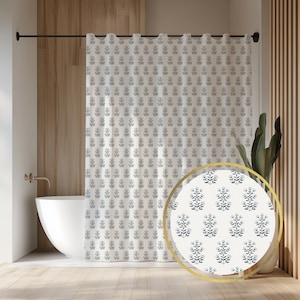 May include: A white shower curtain with a repeating pattern of stylized blue floral sprigs. The curtain is hanging in a bathroom with a white bathtub and wooden accents. A close-up shows the floral pattern.