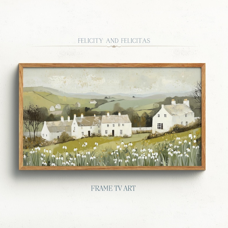 May include: A painting depicting a row of white houses with green roofs set against a backdrop of rolling green hills. The houses are surrounded by white flowers and green trees. The sky is a light blue with white clouds. The painting is titled "Felicity and Felicitas" and is framed in a wooden frame.