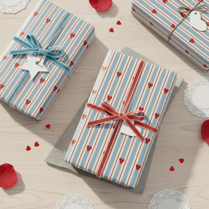 May include: Three wrapped gifts with blue and white striped paper and red heart accents. Each gift is tied with a velvet ribbon and a decorative tag. Scattered around are red heart confetti and paper doilies.