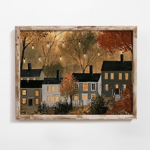 Peut inclure: Une impression d'art mural encadrée représentant une rangée de maisons grises aux toits sombres avec des fenêtres jaunes éclairées au crépuscule. La scène montre des arbres d'automne au feuillage orange, une clôture blanche et des guirlandes.
