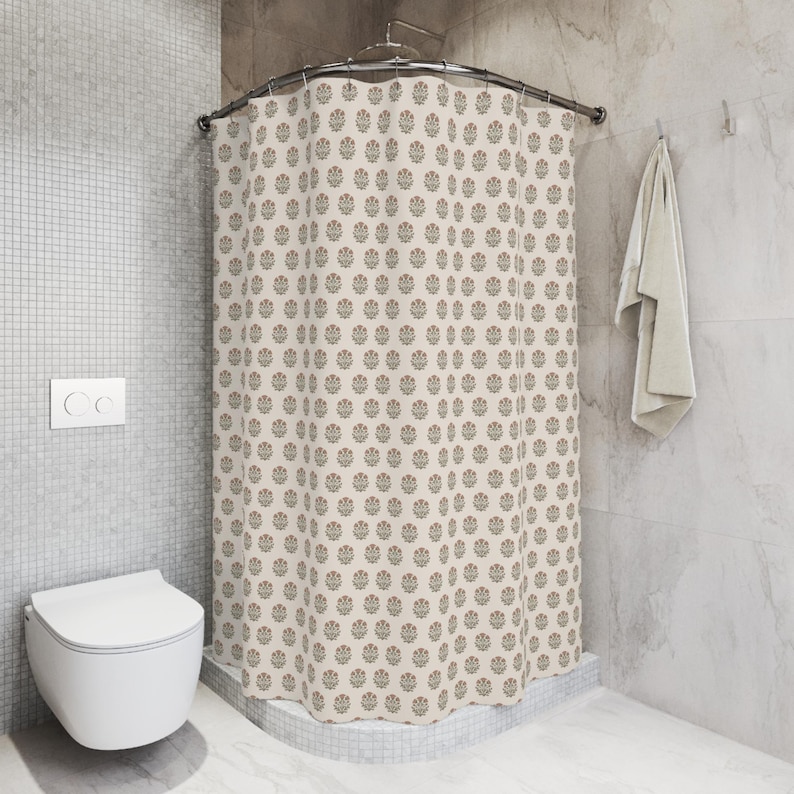 May include: A beige shower curtain with a repeating floral pattern in red, green, and brown. The curtain is hanging in a bathroom with a white toilet and a towel. The walls are tiled in a light gray color.