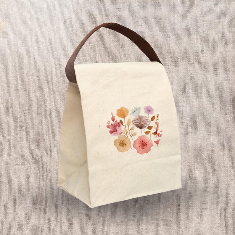 This Floral Canvas Lunch Bag With Strap and loop tape features a cute watercolor floral design, making it a stylish reusable lunch bag for school or office.
