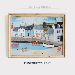 May include: A framed print of a coastal town scene. The artwork shows colorful buildings, boats, and figures along a harbor. The text "FELICITY AND FELICITAS" is at the top, and "PRINTABLE WALL ART" is at the bottom.