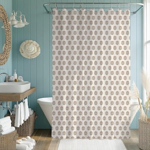 May include: A cream-colored shower curtain with a repeating floral pattern in muted red, green, and brown. The curtain hangs in a bathroom with a white bathtub, a wooden vanity, and a woven basket.