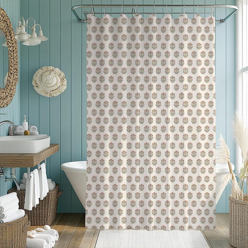May include: A cream-colored shower curtain with a repeating floral pattern in muted red, green, and brown. The curtain hangs in a bathroom with a white bathtub, a wooden vanity, and a woven basket.