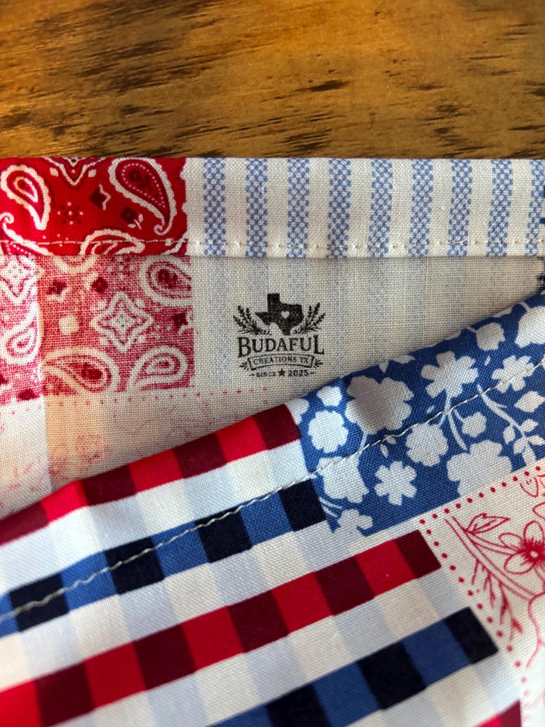 May include: A fabric patchwork textile featuring red paisley, blue and white stripes, blue floral patterns, and red, white, and blue gingham checks. A central logo reads BUDAFUL CREATIONS TX SINCE 2025 with a Texas state silhouette icon.