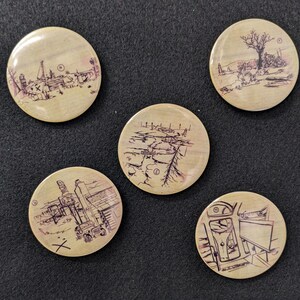 May include: Five round wooden buttons with black and white illustrations of different scenes. The buttons are beige with a wood grain texture.