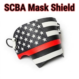 May include: A curved SCBA Mask Shield featuring a black and white American flag design with a prominent horizontal red stripe. The shield includes white stars on a black field, white stripes, and black attachment loops secured with metal rivets.
