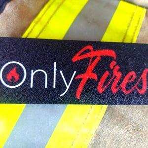 Pode incluir: Um autocolante retangular preto com as palavras "Only Fires" em branco e vermelho. A palavra "Only" está numa fonte limpa sem serifa, e a palavra "Fires" está numa fonte cursiva. Um ícone de chama vermelha está dentro de um círculo branco.