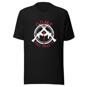 May include: Black t-shirt with a white and red graphic. The graphic features two crossed rifles inside a target, with the words "COME AND TAKE IT" in a circular arrangement around the rifles.